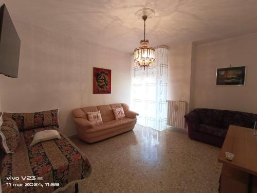 uma sala de estar com um sofá e um lustre em Luisetta em Massafra