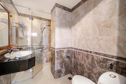 a bathroom with a toilet and a shower and a sink at Titan Hotel Da Nang in Da Nang