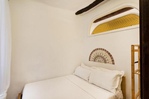 a bedroom with a white bed with two pillows at Cozy Little House in Camogli by Wonderful Italy in Camogli