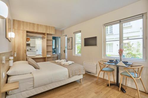 une chambre avec un lit, une table et des chaises dans l'établissement Residence Le Marais by Studio prestige, à Paris