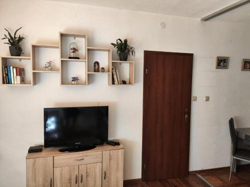 Byt v centre mesta Snina في سنينا: غرفة معيشة مع تلفزيون على خزانة خشبية