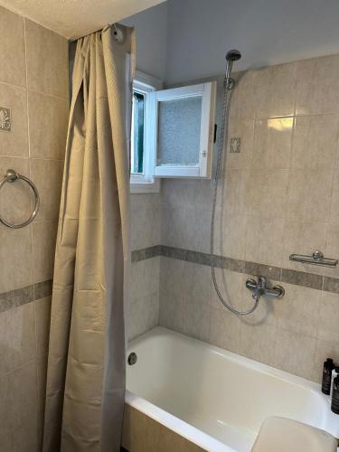 La salle de bains est pourvue d'une baignoire et d'une douche. dans l'établissement LaLaLand, à Mykonos