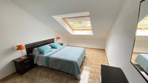- une petite chambre avec un lit et une lucarne dans l'établissement Ático - Avenida Galicia 60, à Finisterre