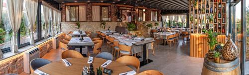 un restaurant avec des tables et des chaises en bois et des fenêtres dans l'établissement Villa Anton, à Sukošan