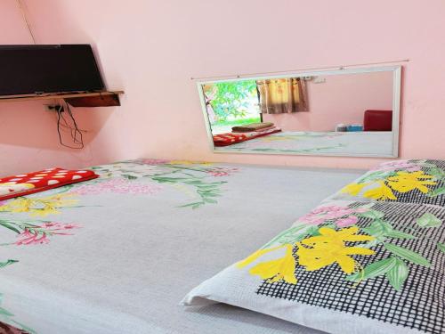 Schlafzimmer mit einem Bett und einem Spiegel in der Unterkunft OYO 75489 Leelawadee NonPho Resort (Amnatcharoen) in Amnat Charoen
