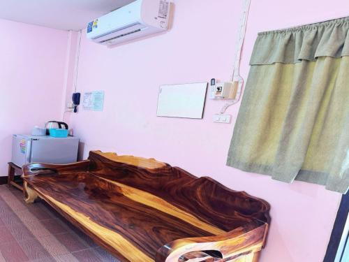 ein Krankenhauszimmer mit einem Holzbett und einem Fenster in der Unterkunft OYO 75489 Leelawadee NonPho Resort (Amnatcharoen) in Amnat Charoen