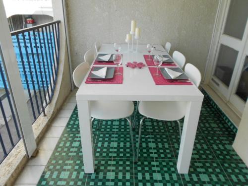 une table blanche avec des chaises blanches et un chiffon de table rouge dans l'établissement Isis, à La Grande Motte