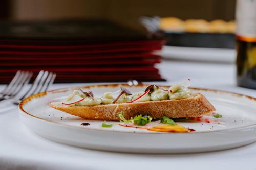 a white plate with a piece of bread with food on it at Hotel Kaštieľ Mojmírovce in Mojmírovce