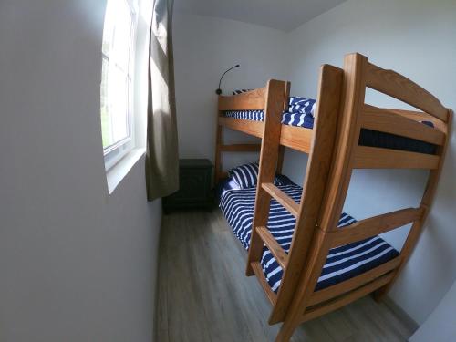 une chambre avec deux lits superposés et une fenêtre dans l'établissement maisonnette pêcheur Bertheaume, à Plougonvelin