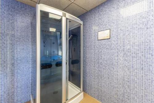 a glass elevator in a room with blue tiles at Los Montero in Villamanrique de Tajo