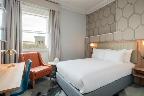 チェスターにあるThe Queen at Chester Hotel, BW Premier Collectionのベッド、デスク、椅子が備わるホテルルームです。
