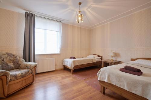 a room with two beds and a couch and a window at Villa Wesenbergh in Rakvere