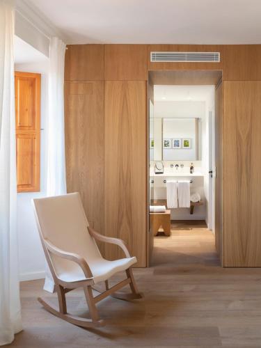 a white chair in a room with a bathroom at Es Figueral Nou Hotel Rural & Spa - Adults Only - Over 12 in Montuiri