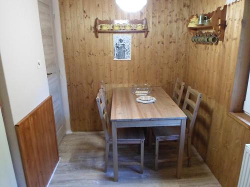 Chata U skřítka في Valašská Bystřice: طاولة وكراسي خشبية في غرفة صغيرة