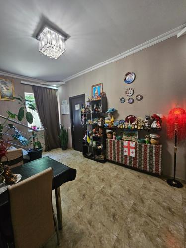 a living room with a table and a chandelier at Guesthouse different in Tbilisi City