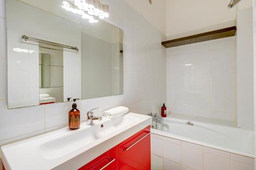 une salle de bain avec un lavabo, un miroir et une baignoire dans l'établissement La Major- Bel appartement dans le centre, à Marseille
