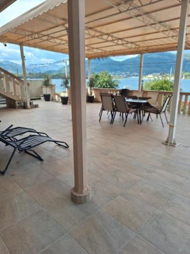 pawilon z krzesłami i stołami oraz widokiem na ocean w obiekcie Apartments Klakor PS w mieście Tivat