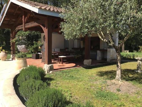 a wooden pavilion in a yard with a tree at Grande maison familiale La Tuilerie in Bourriot-Bergonce