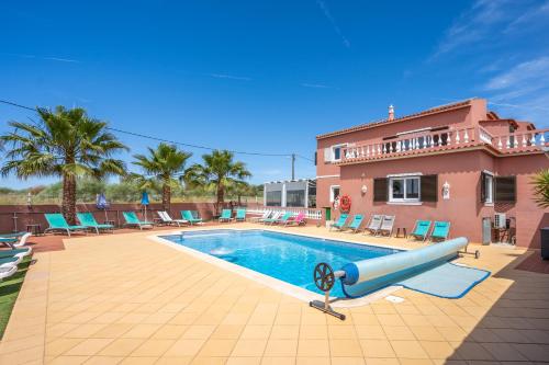 uma piscina em frente a uma casa em Villa Paradis - Quartos em Pêra