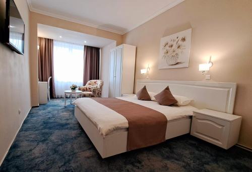 a hotel room with a bed and a chair at Pensiunea Diamant in Ghimbav