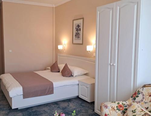 a small bedroom with a bed and a chair at Pensiunea Diamant in Ghimbav