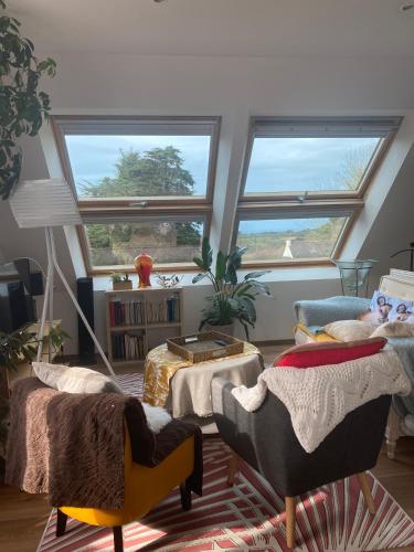 - un salon avec deux chaises et deux fenêtres dans l'établissement Echappée belle au cœur du granit rose, à Perros-Guirec