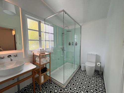 a bathroom with a glass shower and a sink at Floriana Boutique Hotel in Cairns