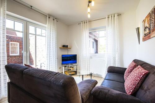 a living room with a couch and a television at Haus Südblick, Wohnung Nr 5 in Werdum