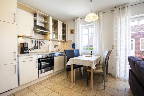 a kitchen and dining room with a table and chairs at Haus Südblick, Wohnung Nr 5 in Werdum