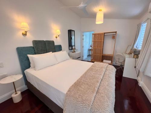 a bedroom with a large white bed with green accents at Floriana Boutique Hotel in Cairns