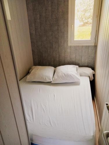 - un petit lit dans une petite chambre avec fenêtre dans l'établissement Au Clair Vallon, à Houlgate