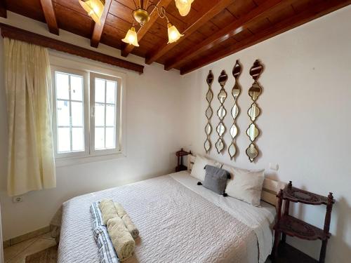 1 dormitorio con cama blanca y techo de madera en Classy Classic en Mykonos ciudad
