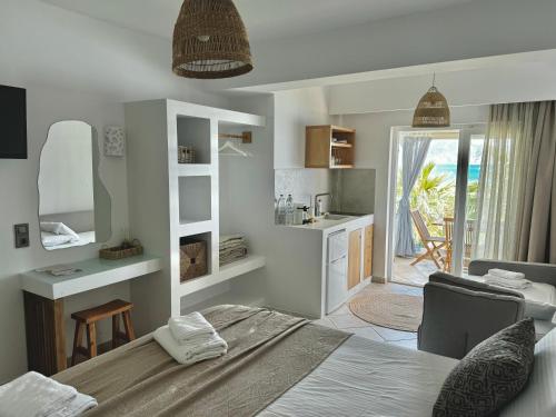 ein Schlafzimmer mit einem Bett und einem Schreibtisch sowie eine Küche in der Unterkunft San Salvatore in Zakynthos
