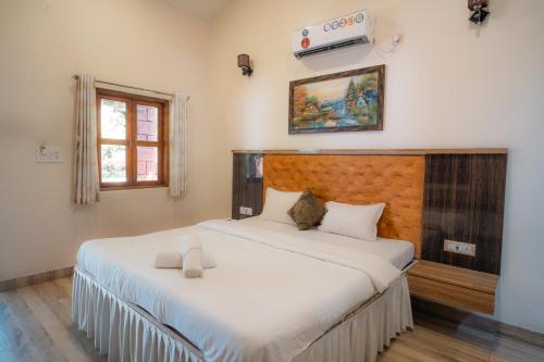 a bedroom with a large bed with white sheets at Hrishivan Resort Nagaon in Nagaon