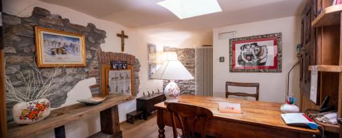 um quarto com uma mesa e uma parede de pedra em Maison Colombot em Aosta