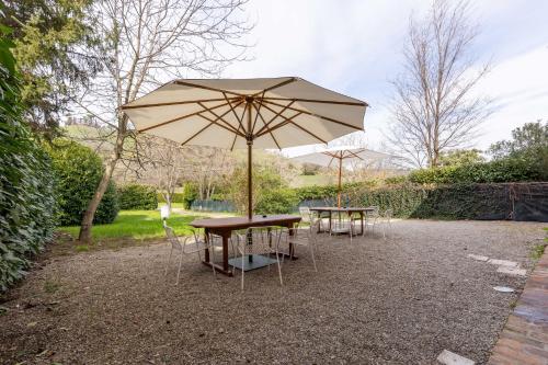 two picnic tables and an umbrella in a park at BolognaRoomscom - Ca' Palazzo in Sasso Marconi