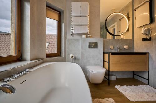 a bathroom with a tub and a toilet and a sink at Hotel Vedmezhyi Dvir in Bukovel