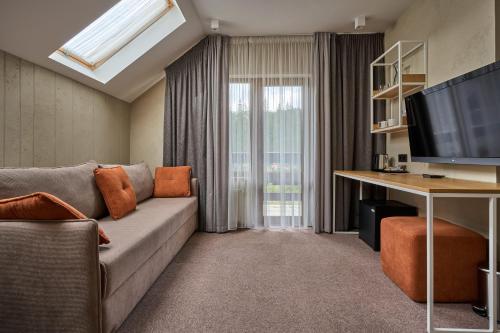a living room with a couch and a television at Hotel Vedmezhyi Dvir in Bukovel