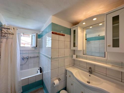 a bathroom with a sink and a tub and a mirror at Classy Classic in Mýkonos City