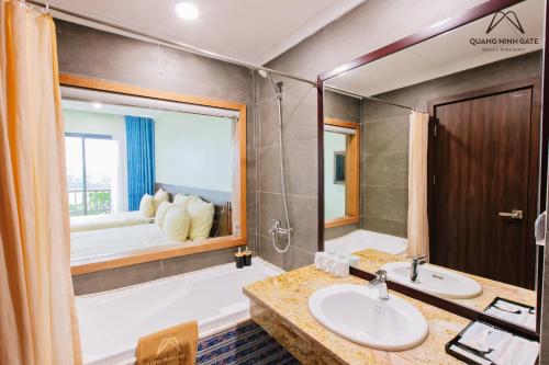 a bathroom with a tub and a sink and a bath tub at Quảng Ninh Gate Hotel & Resort in Bác Mã