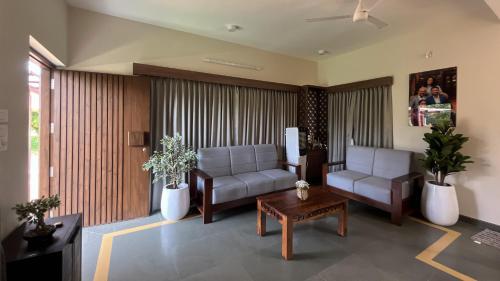 a living room with two couches and a table at Pavo Shores by EWA Properties in Suratakal