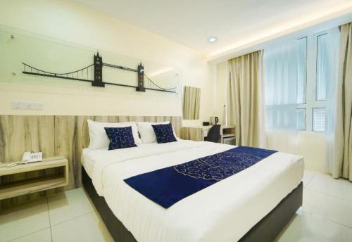 OYO 90975 Atta Hotel في بوكيت ميرتاجام: غرفة نوم بسرير كبير مع جسر على الحائط