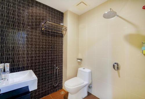 OYO 90975 Atta Hotel في بوكيت ميرتاجام: حمام به مرحاض أبيض ومغسلة