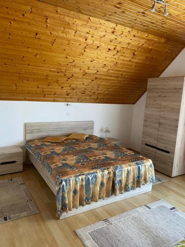 バラトンギュルクにあるLeitner Apartmanの木製の天井の客室のベッド1台分です。