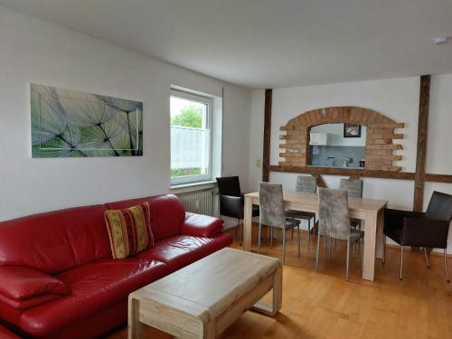 een woonkamer met een rode bank en een tafel bij Gästehaus Walter in Hardt