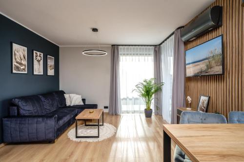 a living room with a couch and a table at Apartamenty i Pokoje Złote Piaski in Jastrzębia Góra