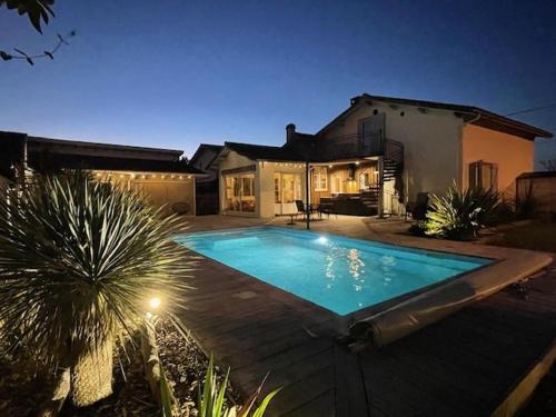 une maison avec une piscine devant une maison dans l'établissement VILLA LANDES ANGELES - Maison avec piscine à 6km de l'océan, à Mimizan