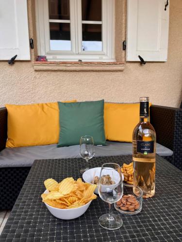 - une table avec une bouteille de vin et des chips ainsi que des verres à vin dans l'établissement La Cigalière, à Saint-Raphaël