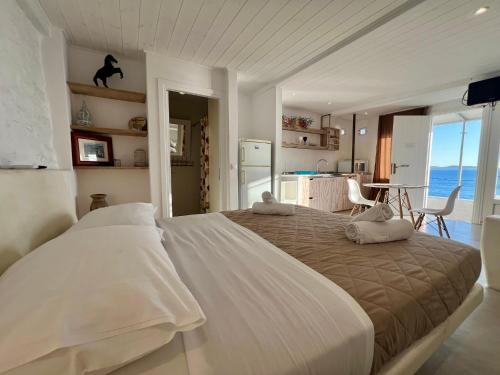 a bedroom with a large white bed with a view of the ocean at Mykonos Tourlos Nests - Sea View Escape in Tourlos