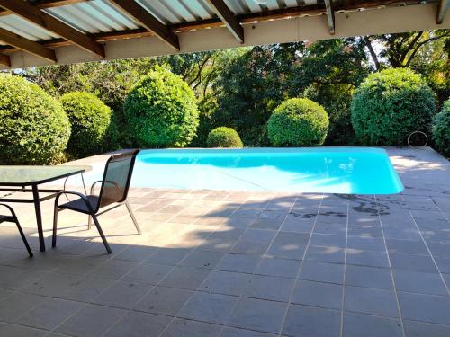 una piscina con mesa y sillas en un patio en Thandanani Serene place, en Pietermaritzburg